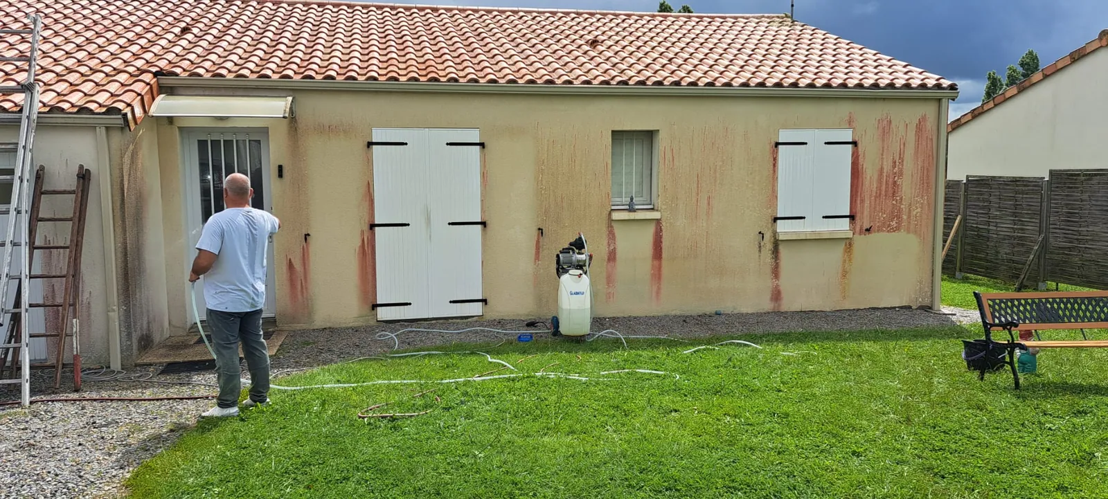 Application du traitement de façade au pulvérisateur sur les murs tachés de rouge
